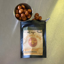 Bag of Kauai Gourmet Nuts Coconut Bliss macadamias with a bowl of nuts on a reflective surface