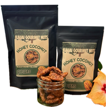 Two packages of Kauai Gourmet Nuts Honey Coconut pecans with a jar of pecans and a flower.